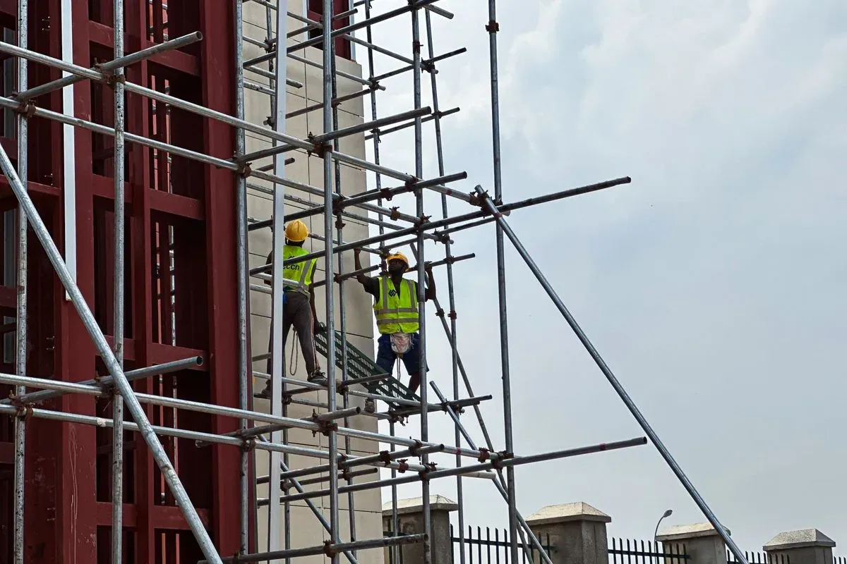 Operarios en obra de hormigón con andamios